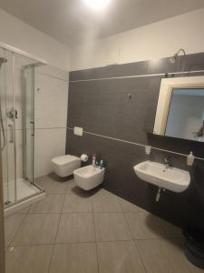 a bathroom with two sinks and a shower and a toilet at Le Dune per 4 in Silvi Marina