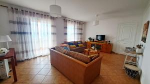 a living room with a couch and a tv at Villa Abreu in Ponta do Sol +13 photos