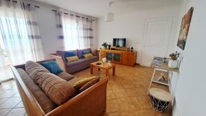 a living room with a couch and a tv at Villa Abreu in Ponta do Sol