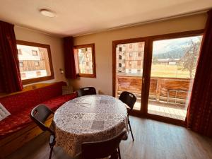 a room with a table and a couch and a window at Le Chalet de Super D in Le Dévoluy