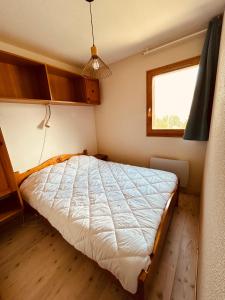 a bedroom with a bed in a room with a window at Le Chalet de Super D in Le Dévoluy