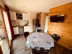 a room with a table and chairs and a kitchen at Le Chalet de Super D in Le Dévoluy