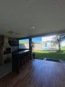 a kitchen with a counter and a table and chairs at Casa para temporada Diversão e sossego PRÓXIMA A PRAIA in Rio das Ostras