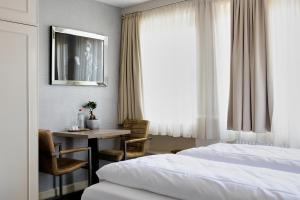 a hotel room with a bed and a table and a desk at Living am Carlsplatz Apartment in Düsseldorf