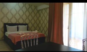 a bedroom with a bed with a table and a window at Hotel G&G in Tsaghveri