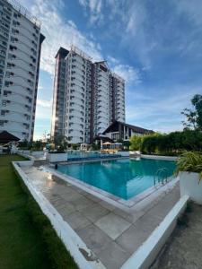 a swimming pool in front of some tall buildings at Cozy Crib at Royal Oceancrest Mactan in Mactan Island