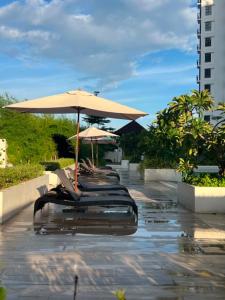 a row of chairs with umbrellas on a patio at Cozy Crib at Royal Oceancrest Mactan in Mactan Island