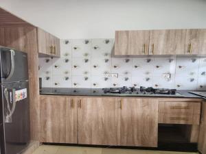 a kitchen with wooden cabinets and a stove top oven at D-vine Apartments & Hotels in Benin City
