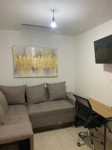 a living room with a couch and a desk at Ruah Home in Guadalupe