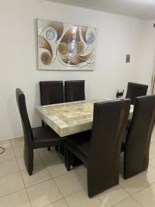 a dining room table with black chairs and a marble table top at Ruah Home in Guadalupe +4 photos