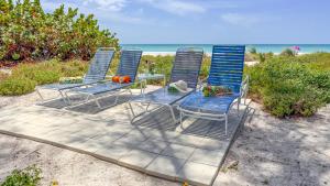 a group of blue chairs sitting on the beach at Bamboo Apartments in Holmes Beach