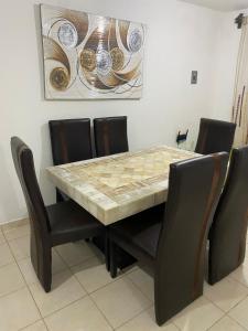 a dining room table with chairs and a marble table top at Ruah Home in Guadalupe