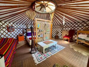 a yurt with a bed and a table in a room at La Yourte climatisée du Jardin Caché in Marmande +11 photos