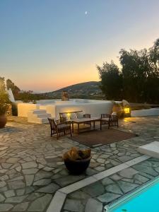 a patio with a table and chairs next to a pool at Paros Casa Prive in Vrachonisída Loúmpinas