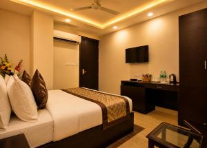 a bedroom with a bed and a desk and a television at Hotel Kings Inn, Karol Bagh, New Delhi in New Delhi