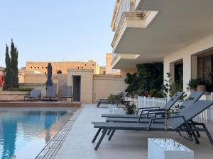 a patio with chairs and a pool on a building at B6 Dahlet Ta Cenc in Sannat