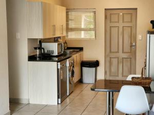 a small kitchen with a table and a microwave at Comfort & Style at the Ihita Complex - Beverley, Sandton in Sandton