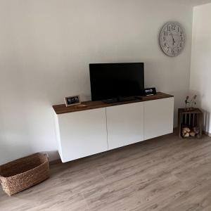 a living room with a tv on a white cabinet at Casa-Heckl in Tutzing