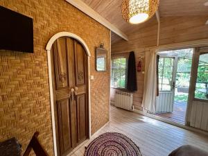 a room with a door and a tv on a wall at Le chalet du Jardin caché in Marmande