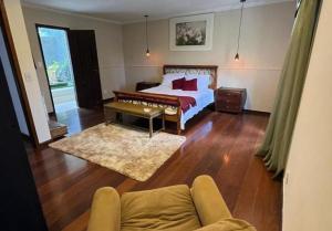 a bedroom with a bed and a couch at Alto Paraiso in Teresópolis