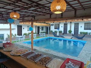 a resort pool with tables and chairs and lights at V Hostel Galera in Puerto Galera