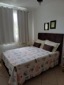a bedroom with a bed with a blanket on it at Apartamento Orquídea in Campos dos Goytacazes