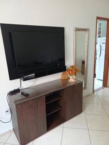a flat screen tv sitting on top of a wooden entertainment center at Apartamento Orquídea in Campos dos Goytacazes