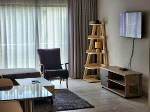 a living room with a couch and a table and a ladder at Comfort & Style at the Ihita Complex - Beverley, Sandton in Sandton