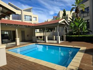 a swimming pool in front of a house at Comfort & Style at the Ihita Complex - Beverley, Sandton in Sandton