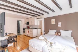 a large bedroom with two beds and a kitchen at Alma do Bairro in Lisbon