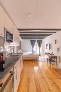a kitchen and living room with a bed in the background at Alma do Bairro in Lisbon