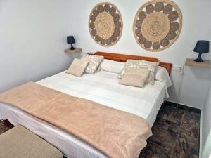 a bed in a room with two pictures on the wall at Luz del Mar in Órzola