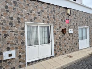 a stone wall with two doors on a building at Luz del Mar in Órzola