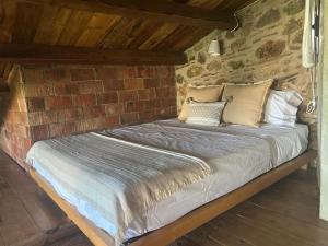 a bed in a room with a brick wall at Can Cirili Rustic Romantic apartment for couples or family events in Bordils