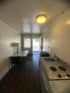 a kitchen with a stove and a table with a lamp at Union Avenue Motel in Portland