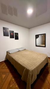 a bed in a room with pictures on the wall at Casa comoda con aire y garaje en La Union Valle in Lemos