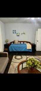 a bedroom with a blue bed and a couch at Private Cottage in Rural Clemmons in Clemmons