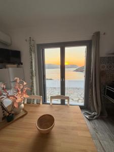 a room with a table with a view of the ocean at PANDORA Φουρνοι Κορσεων in Nisída Foúrnoi +27 photos
