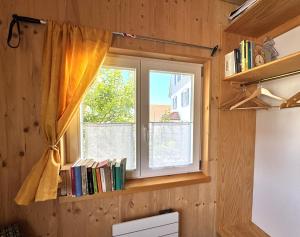 a window in a room with books on it at Tiny-Ferienhäusle Casa Wendy in Loßburg +26 photos
