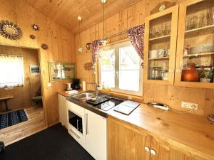 a kitchen with wooden cabinets and a counter top at Tiny-Ferienhäusle Casa Wendy in Loßburg