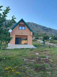 a small house in a field with a hill in the background at Gabriels7 in Korita
