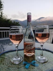 a bottle of wine and two glasses on a table at Drina Lake House in Zvornik