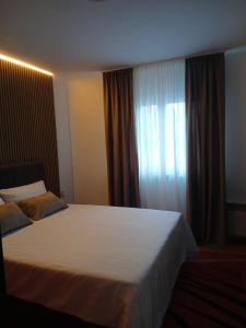a bedroom with a large white bed with a window at Drina Lake House in Zvornik