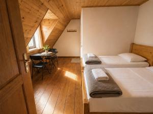 two beds in a small room with a table at Guesthouse Pashko in Theth
