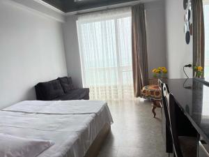 a bedroom with a bed and a couch and a window at Mari House in Buknari