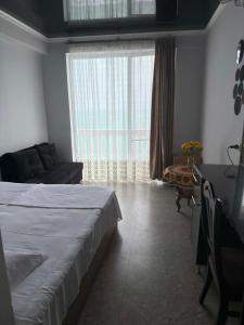 a bedroom with a bed and a couch and a window at Mari House in Buknari +4 photos