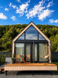 a tiny house with a large window and two chairs at Carpathian Barns in Abranka