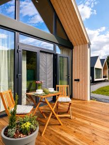 a patio with a table and chairs on a wooden deck at Carpathian Barns in Abranka