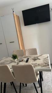a dining room table with chairs and a flat screen tv at Olimpik bic in Paralia Katerinis