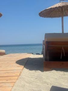 a sandy beach with an umbrella and the ocean at Olimpik bic in Paralia Katerinis +5 photos